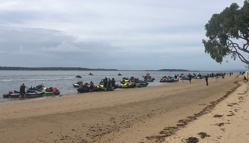 Scores of jet-ski riders and their jet-skis parked on the shoreline of Norfolk Beach, Coochiemudlo Island.